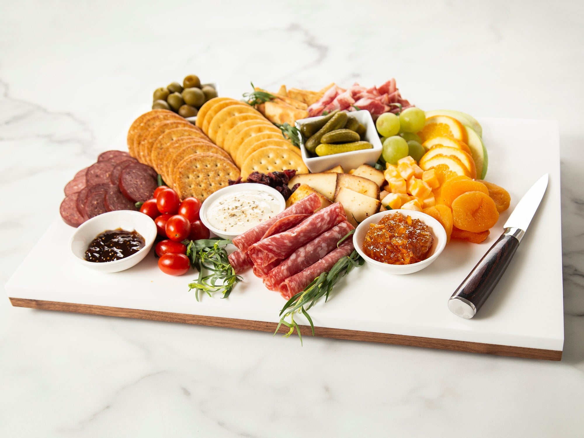 Be the talk of the party with the Black Walnut & Corian Charcuterie Board! This stunning pairing of black walnut wood and corian offers a chic, modern look, making it the perfect choice for a housewarming, wedding or any special occasion. Wow your guests with your excellent taste and make a great impression!
