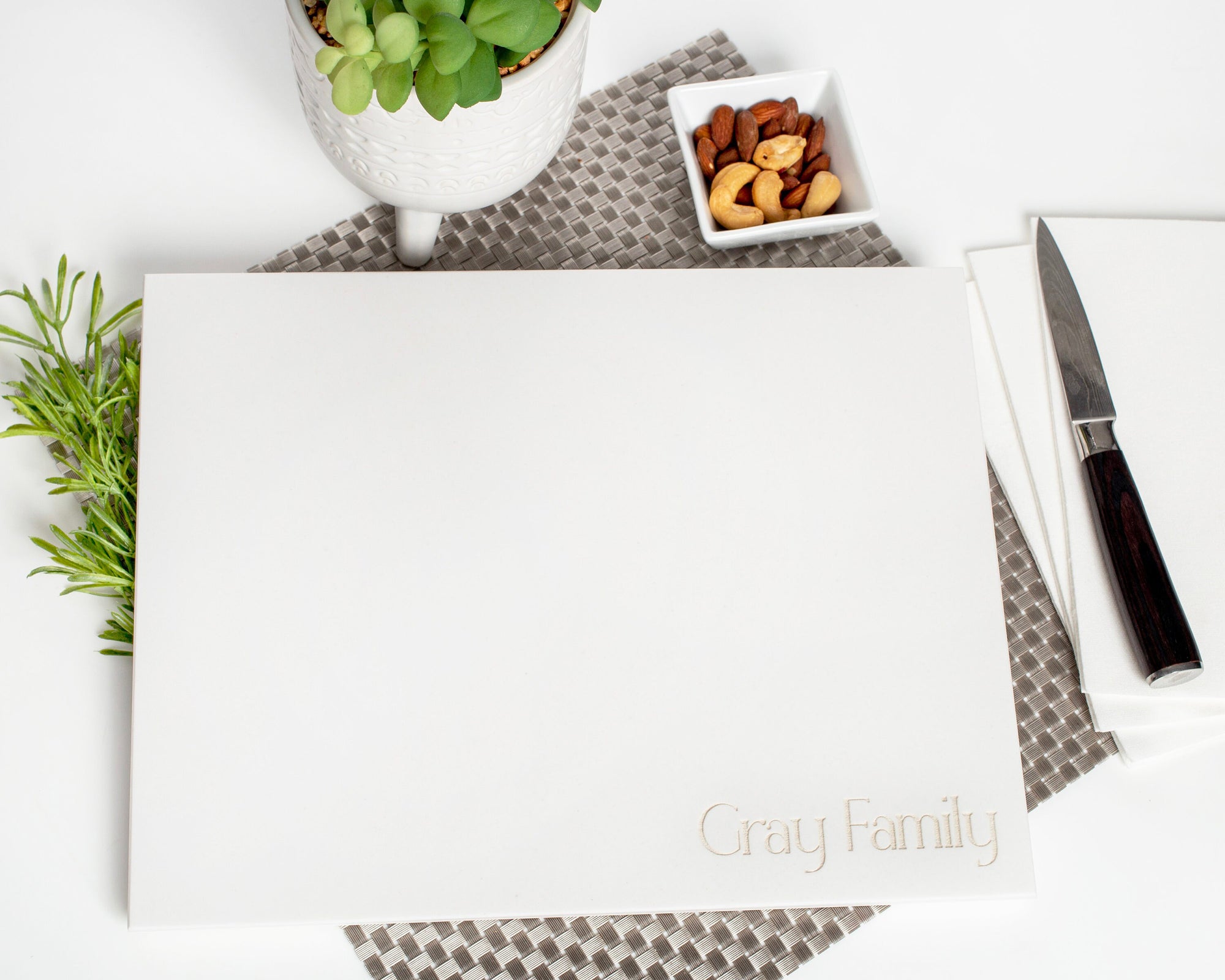 Create an elegant center piece for your kitchen with this White Corian Personalized Cutting Board. It is crafted from high-quality materials for maximum durability and features a unique and stylish design for a distinctive look. Perfect for both daily use and special occasions.